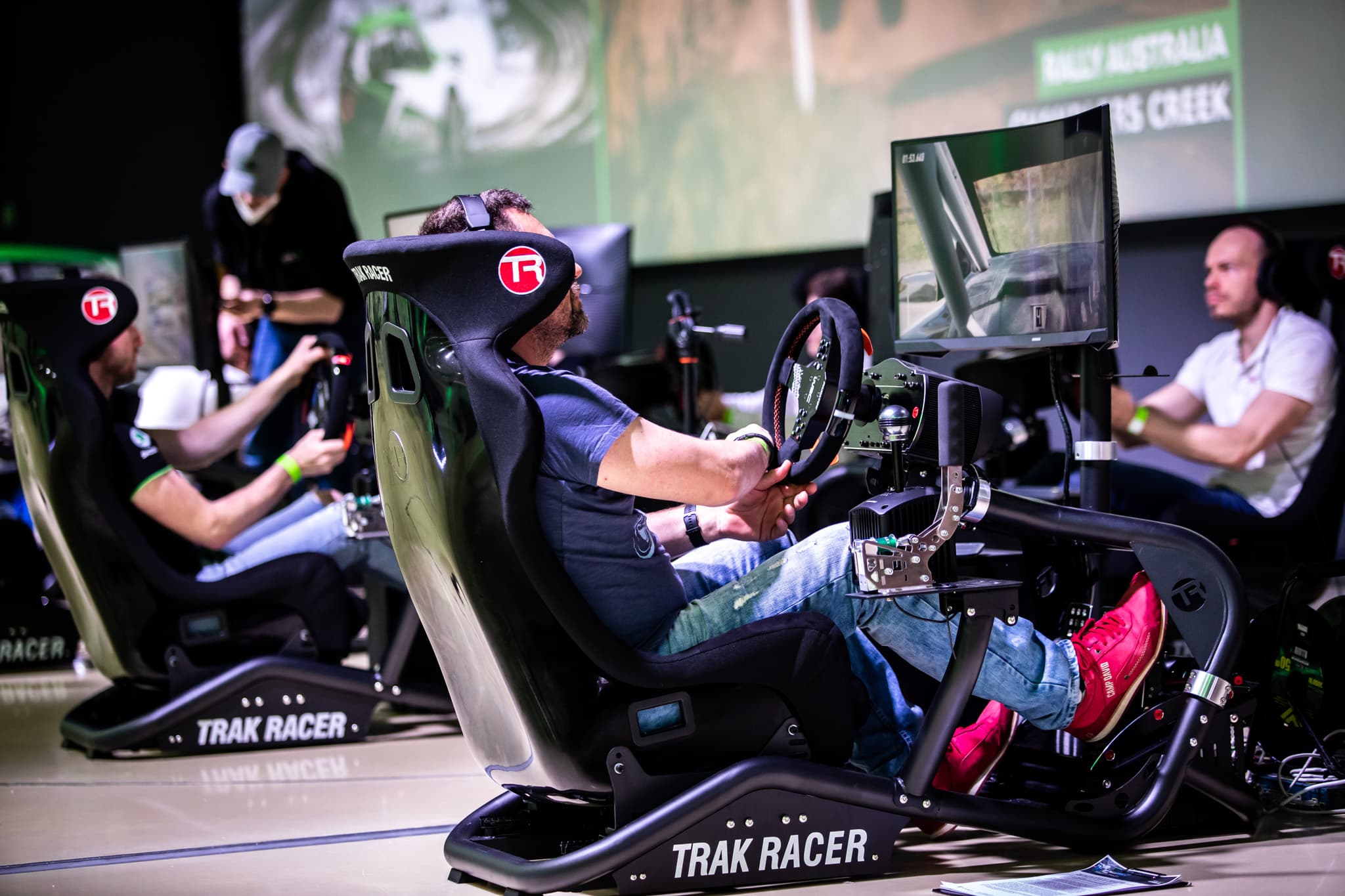 Závod na simulátorech v plném běhu, hosté jedou a tým Digital Racing hlídá průběh